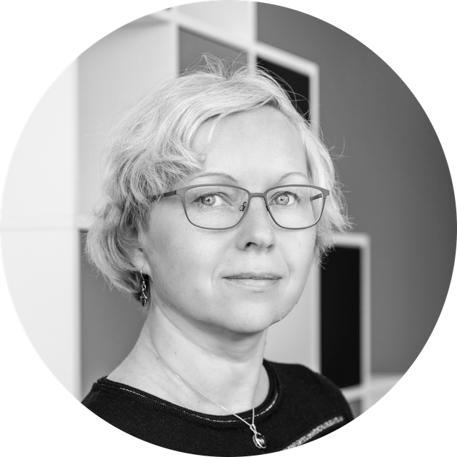 Black and white portrait of a person with short hair wearing glasses and looking at the camera.